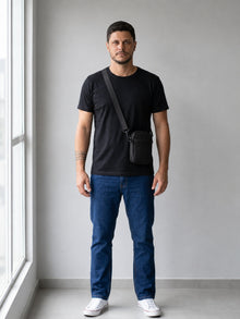 Homem de corpo inteiro usando a shoulder bag masculina preta atravessada no peito