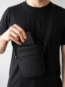 Celular sendo guardado na shoulder bag preta, segunda vista
